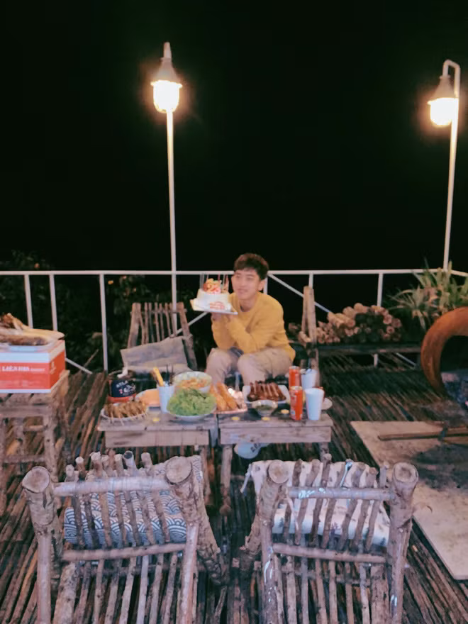 Chủ thể ngồi cầm bánh sinh nhật nhưng đứa bạn thân lại lấy nét vào tiền cảnh.