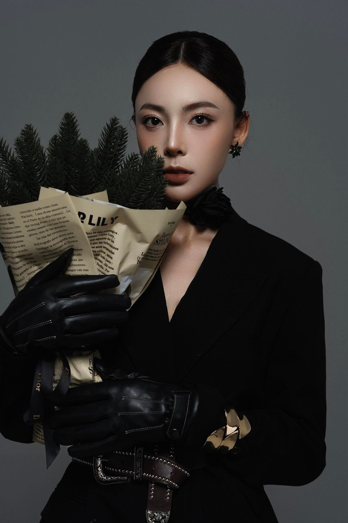 Nàng hot girl của làng bắn súng Việt Nam diện chiếc vest đen với những phụ kiện vàng làm điểm nhấn.