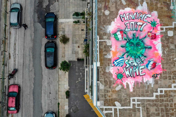 Tại sân thượng của một tòa nhà ở Athens, Hy Lạp, một nghệ sĩ 16 tuổi đã vẽ một bức tranh với dòng chữ 'Hãy ở nhà', kêu gọi người dân hạn chế ra đường và đến các khu vực công cộng, giữ khoảng cách xã hội để hạn chế sự lây lan của dịch bệnh COVID-19.