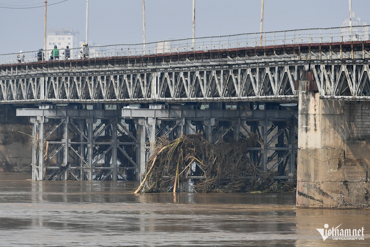 Tại các mố trụ chống va đập cạnh cầu Long Biên, xuất hiện những thân cây lớn mắc kẹt, đọng lại sau khi dòng chảy đã giảm mạnh so với mấy ngày trước.