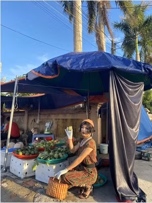 Sự xuất hiện của "thánh bán hàng online" khiến cả khu chợ phải chăm chú nhìn theo.