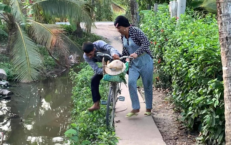 Đi được một đoạn, anh chồng lại nhảy xuống đi bộ, lôi “nóc nhà” xềnh xệch phía sau. Hứng chí lên lại nhảy lên lưng, bắt vợ cõng.