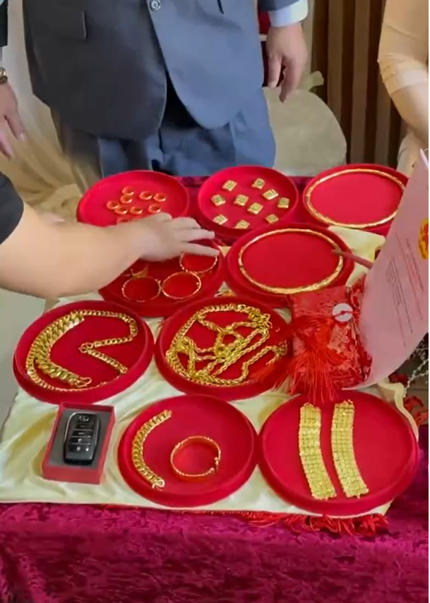 Trong không khí rộn ràng, MC vui mừng giới thiệu của hồi môn: "1kg vàng trị giá hơn 26 cây. Chưa chưa, còn 1 chiếc xe Camry 4 chỗ 1 tỷ 6. Chưa chưa, còn 1 ngôi nhà nữa".