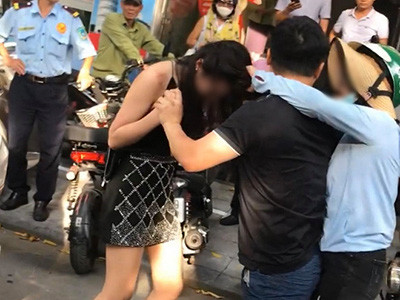 Thấy cảnh vợ xô xát như vậy, người chồng xông vào giữ chặt lấy tay vợ để... bảo vệ cho cô gái trẻ. Thậm chí, người đàn ông này còn đánh đấm và thúc khuỷu tay nhiều cái vào mặt vợ khiến những người đứng xung quanh chứng kiến hết sức bất bình.