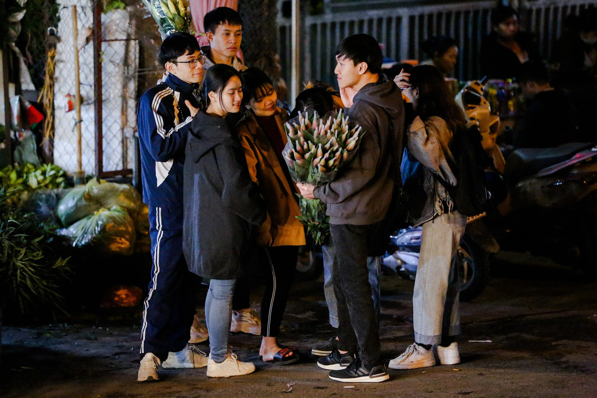 Một nhóm bạn trẻ đến với chợ hoa đêm Quảng An vừa ngắm hoa vừa mua về trang trí nhà.