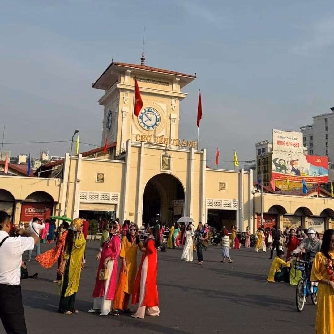 Khắp nơi đều rực rỡ sắc màu của những bộ áo dài. Dòng người nô nức kẻ chụp, người tạo dáng khắp con phố trước cổng chợ Bến Thành tạo nên không khí cực kỳ nhộn nhịp.