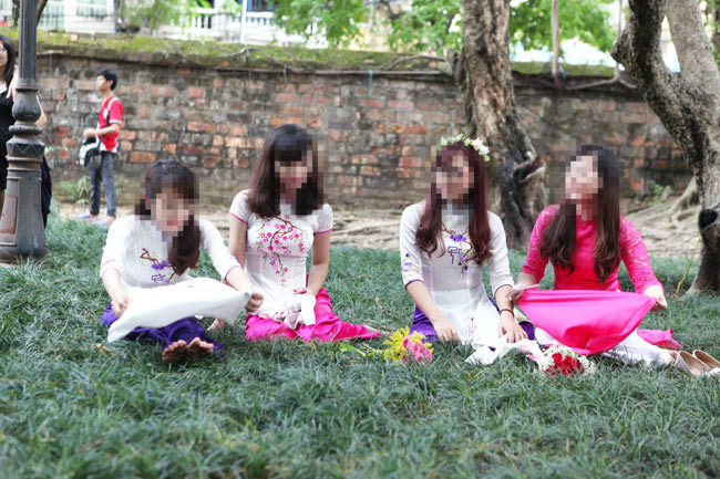 Nhóm nữ sinh từng nhận không ít gạch đá khi chụp ảnh kỉ yếu tại Văn Miếu cố ý ngồi lên cỏ dù đã có biển cấm.