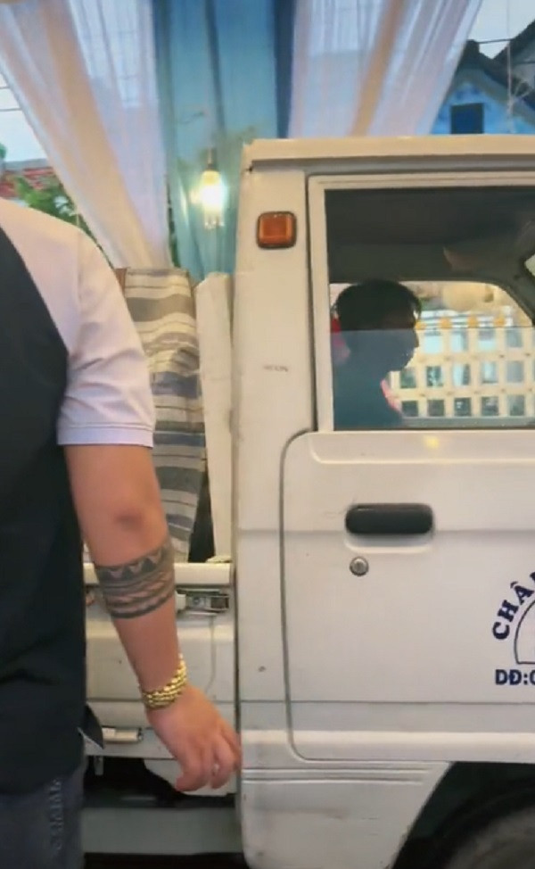 Một bên là dàn khách mời đang ăn cỗ linh đình, một bên là xe bán tải chạy qua.