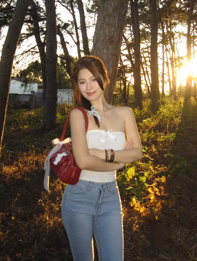 Người đẹp sinh năm 2000 diện quần jeans kết hợp với áo cúp ngực màu trắng, để lộ nguyên phần vai