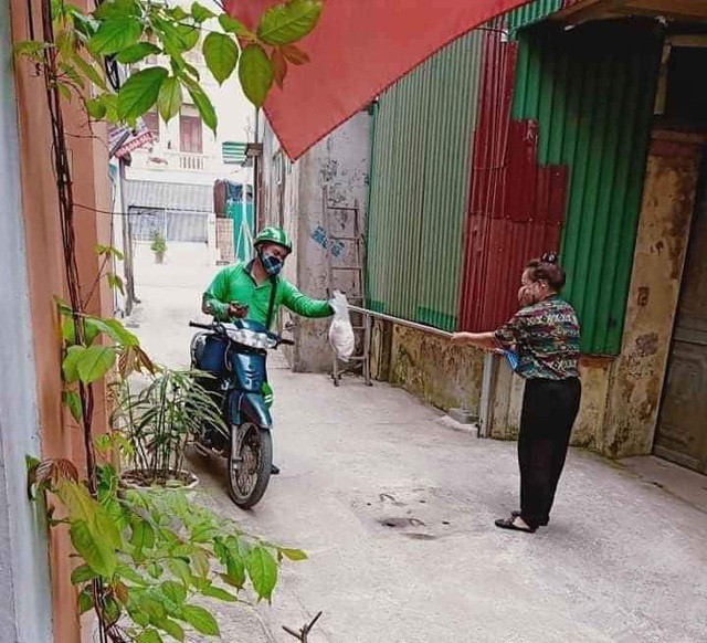Để đảm bảo khoảng cách an toàn với khách trong mùa dịch một chàng tài xế xe ôm có kèm dịch vụ giao hàng đã chủ động nhờ khách dùng gậy để đưa hàng cho mình.