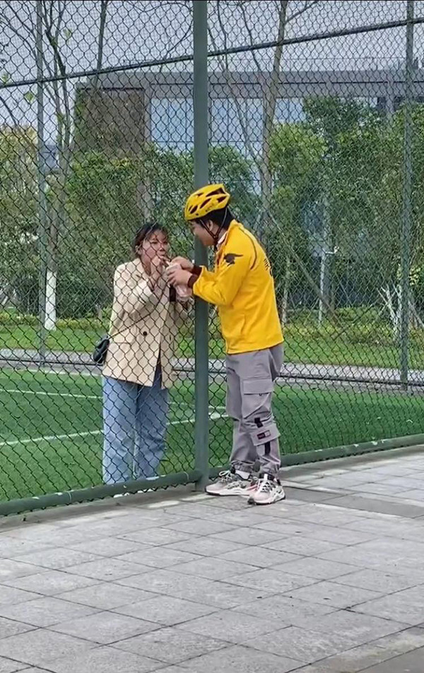 Nhìn từ trên xuống dưới đều không có khe hở nào để đưa trà sữa lọt vào cho cô gái, anh chàng shipper lại nghĩ ra cách khá độc đáo – đưa ống hút trà sữa để cô gái ở bên trong sân có thể uống nước.