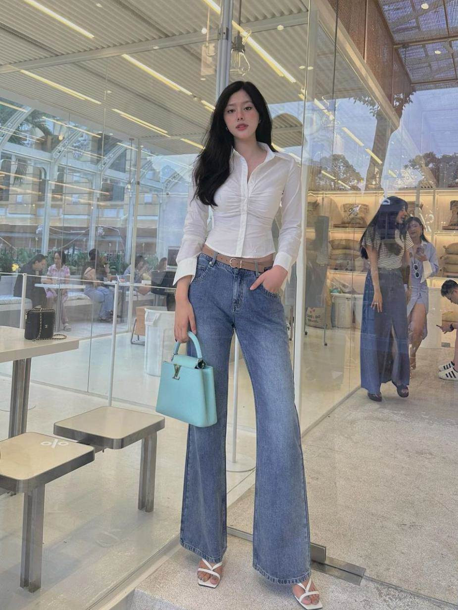 Ngoài các kiểu váy cúp, áo hai dây quyến rũ, dù mặc kín cổng cao tường như áo sơmi, quần jeans ôm song người đẹp cao 1,82m vẫn biết cách khéo tôn hình thể.