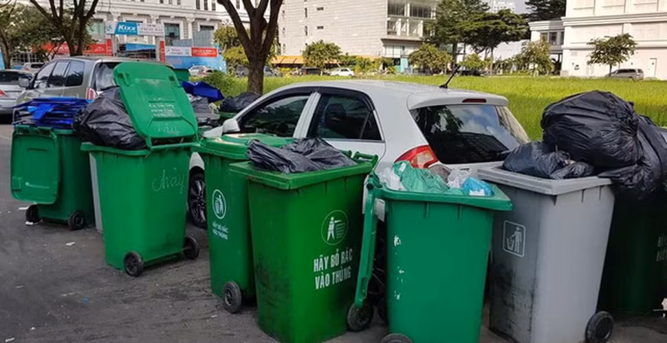 Chiếc xe trắng đáng thương bị bao vây bởi những chiếc xe đựng rác màu xanh.