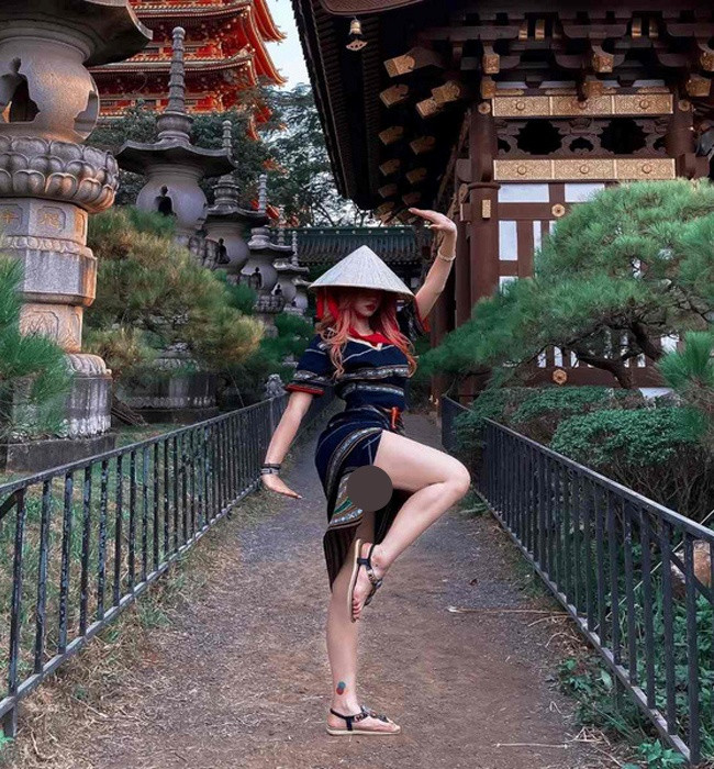 Lê Bống mặc bộ đồ dân tộc tạo dáng co chân để chụp ảnh, chiếc váy xẻ cao khiến nhiều người nhận xét là "kém duyên".