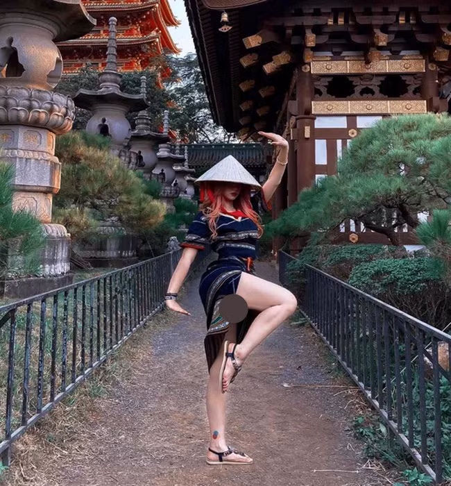 Lê Bống mặc bộ đồ dân tộc tạo dáng co chân để chụp ảnh, chiếc váy xẻ cao khiến nhiều người nhận xét là "kém duyên".