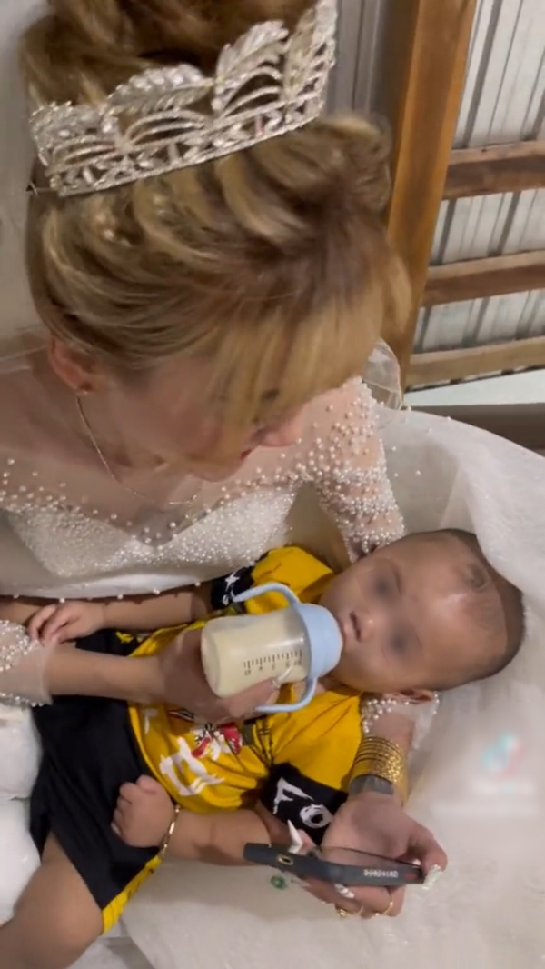 Nhìn dáng dấp có thể đoán được cậu bé cũng đã hơn 1 tuổi. Nằm trong vòng tay mẹ, em bé rất ngoan ngoãn, nằm yên để mẹ cho uống sữa.