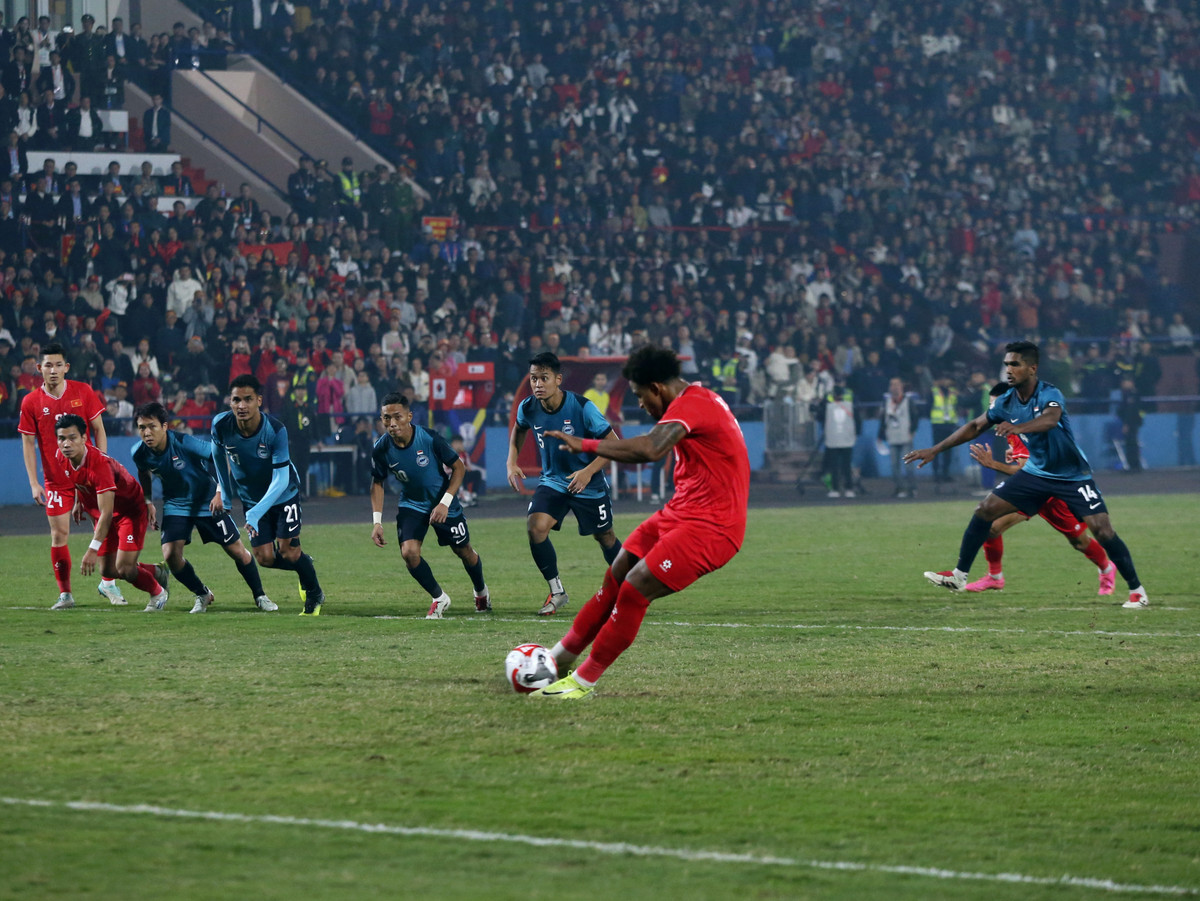 Phút 38, từ tình huống đá phạt bên cánh trái, Hai Long quyết định dứt điểm thẳng đưa bóng dội xà ngang khung thành Singapore. Tuy nhiên, trong tình huống này, Nguyễn Xuân Son đã bị cầu thủ đội khách phạm lỗi dẫn đến rách áo. VAR lập tức vào cuộc xác định lỗi. Trên chấm 11m, đích thân Xuân Son dễ dàng đánh lừa thủ môn Bin Mahbud để mở tỷ số cho Đội tuyển Việt Nam.