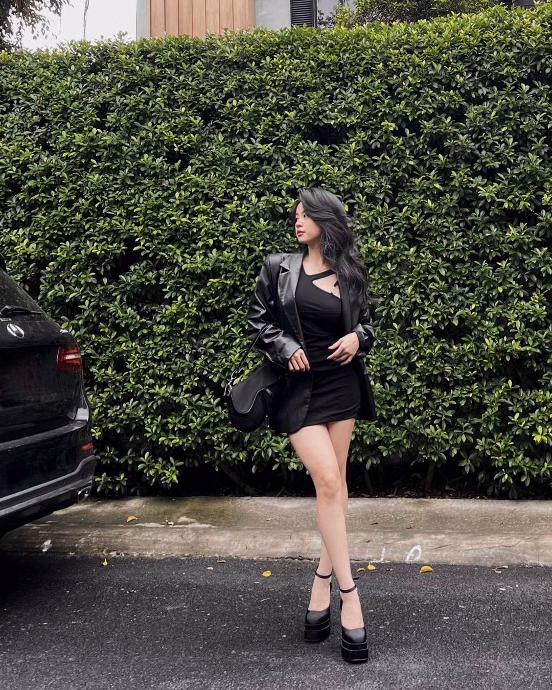 Cách phối đồ "all black" chưa bao giờ lỗi mốt bởi nó mang đến sự thời thượng cho người diện. Hàn Hằng diện váy dáng ôm cut-out lệch bên phối cùng áo khoác da, túi và giày cùng màu.