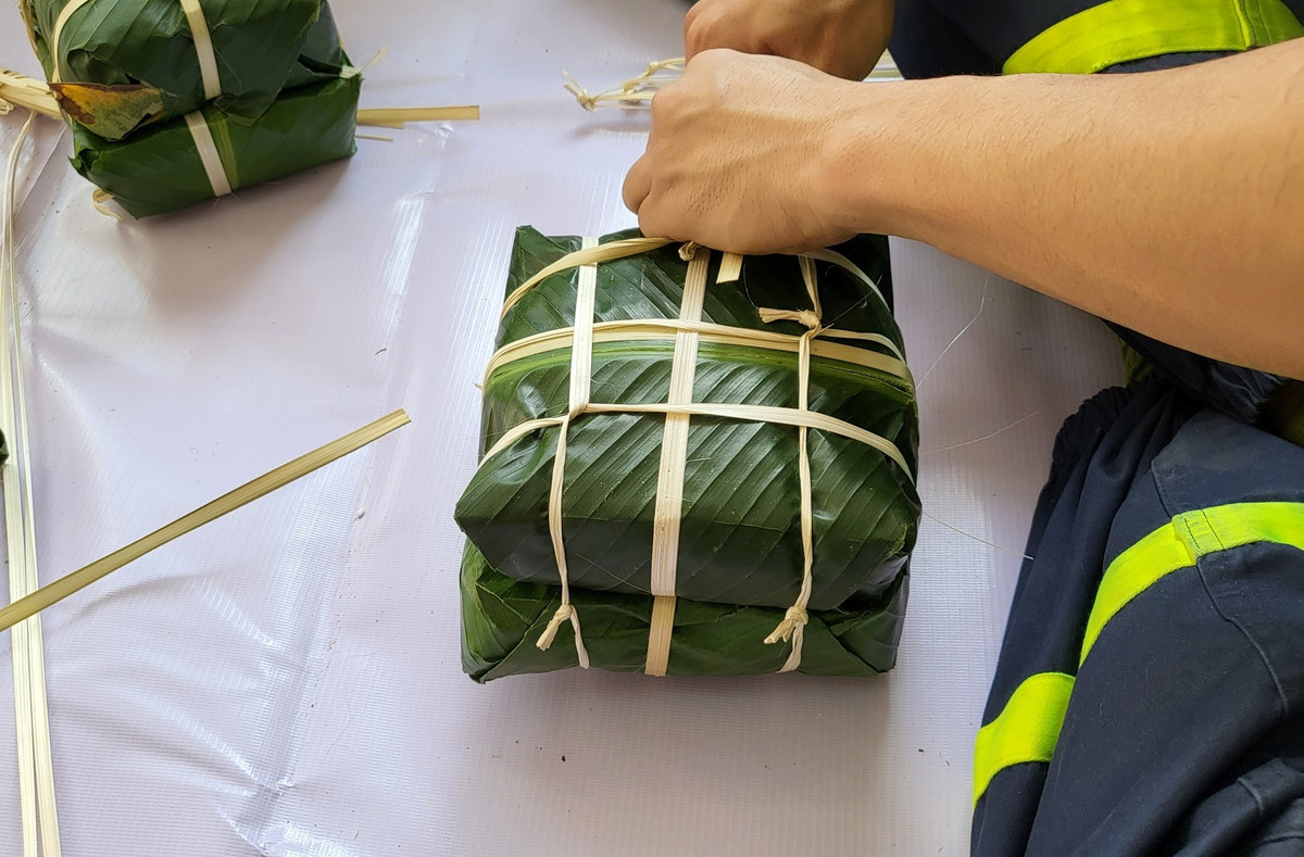 Những bàn tay của lính PCCC mạnh mẽ chiến đấu với "giặc lửa" nhưng cũng vô cùng khéo léo gói những chiếc bánh chưng Tết.
