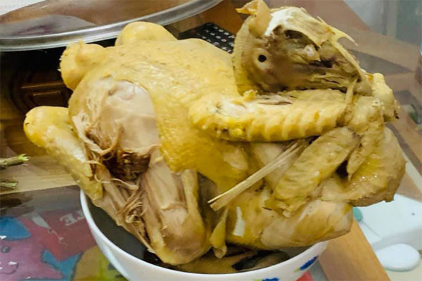 Con gà luộc trên mâm nhưng hình dáng lại không còn nguyên vẹn.