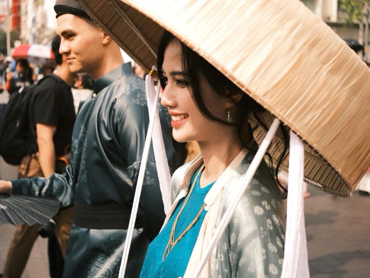 Quỳnh Anh mặc bộ áo ngũ thân thời Nguyễn, phối với yếm và đụp, mặc thả áo để lộ yếm trong theo lối mặc xưa của người miền Bắc, hòa vào dòng người diễu hành trên phố đi bộ Nguyễn Huệ.