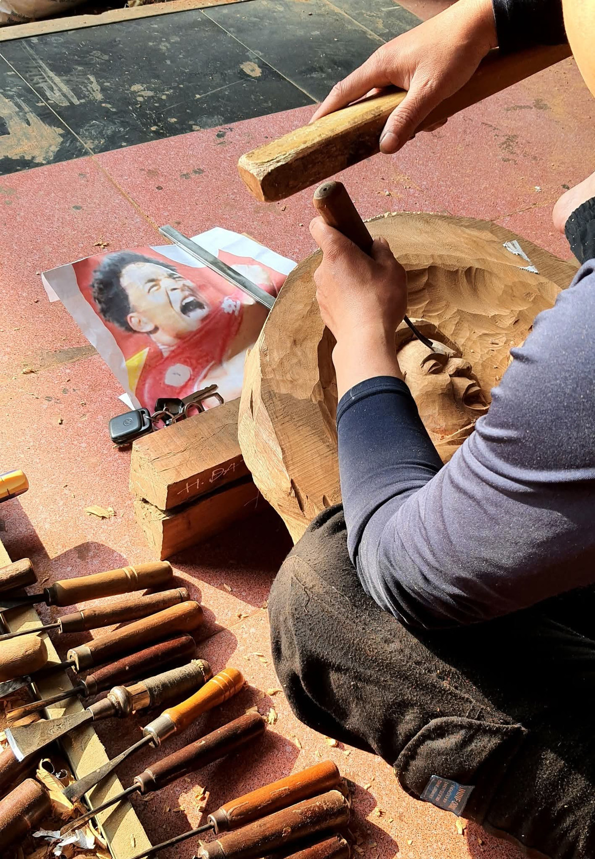 Ấn tượng với hình ảnh của Xuân Son cả trong sân và ngoài sân, các anh em tại xưởng bàn nhau làm một bức tranh chân dung khắc gỗ mô phỏng lại khoảnh khắc chiến thắng đó.