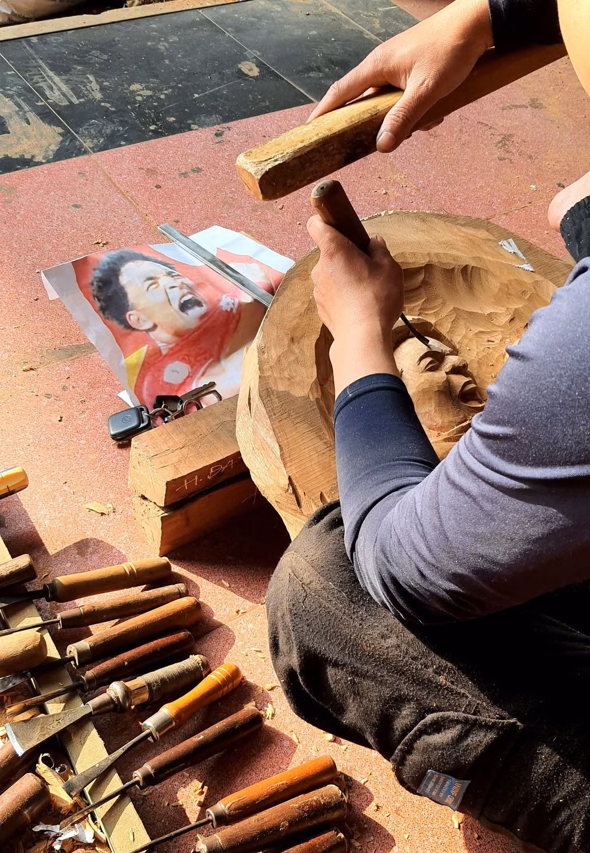 Ấn tượng với hình ảnh của Xuân Son cả trong sân và ngoài sân, các anh em tại xưởng bàn nhau làm một bức tranh chân dung khắc gỗ mô phỏng lại khoảnh khắc chiến thắng đó.