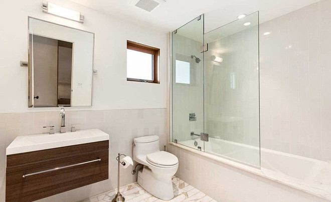 Nhà vệ sinh trang bị bồn tắm lớn và sàn lát đá cẩm thạch. Ảnh: Alexis Adam.