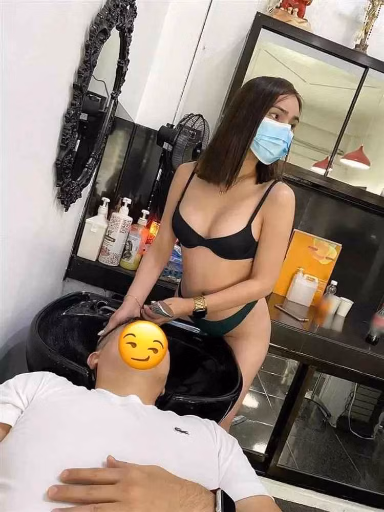 Cụ thể, cô gái với gương mặt khá trẻ đẹp, chỉ mặc mỗi bộ đồ lót, tóc xõa, đeo khẩu trang đứng gội đầu cho khách hàng.