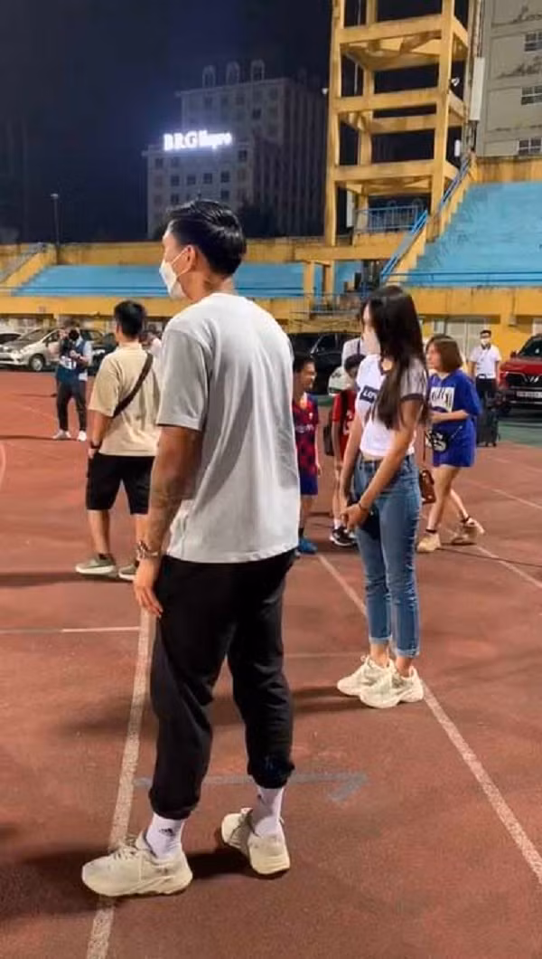 Đoàn Văn Hậu và Doãn Hải My ngồi trên khán đài cổ vũ các đồng đội thi đấu. Sau khi kết thúc 90 phút trên sân Hàng Đẫy, nam cầu thủ cùng bạn gái đã rời khán đài để xuống sân.