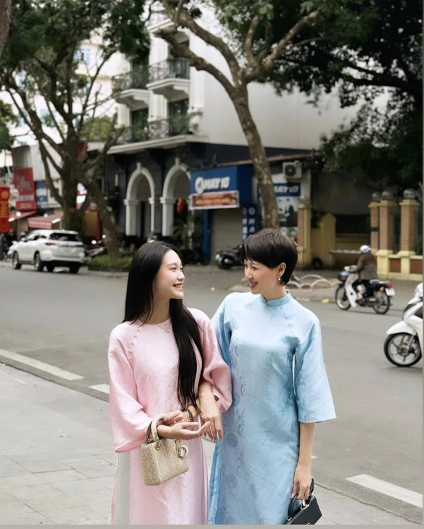 Nàng WAG sinh năm 2001 thì sở hữu phong thái dịu dàng, nhan sắc đằm thắm trong tà áo dài truyền thống với màu sắc thanh nhã. Mẹ đẻ thì trang điểm nhẹ nhàng vẫn cuốn hút.