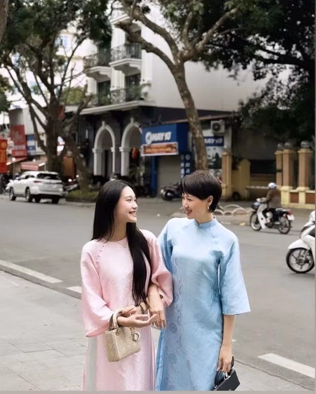 Nàng WAG sinh năm 2001 thì sở hữu phong thái dịu dàng, nhan sắc đằm thắm trong tà áo dài truyền thống với màu sắc thanh nhã. Mẹ đẻ thì trang điểm nhẹ nhàng vẫn cuốn hút.