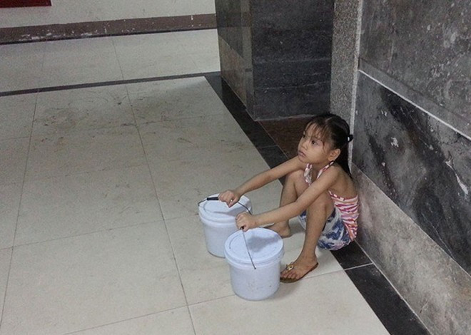 Hình ảnh em bé 7 tuổi phải đi xách nước vì bố vắng nhà, mẹ vừa sinh em bé được netizen chia sẻ trên nhiều hội nhóm.