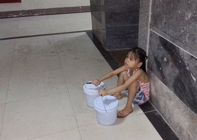 Hình ảnh em bé 7 tuổi phải đi xách nước vì bố vắng nhà, mẹ vừa sinh em bé được netizen chia sẻ trên nhiều hội nhóm.