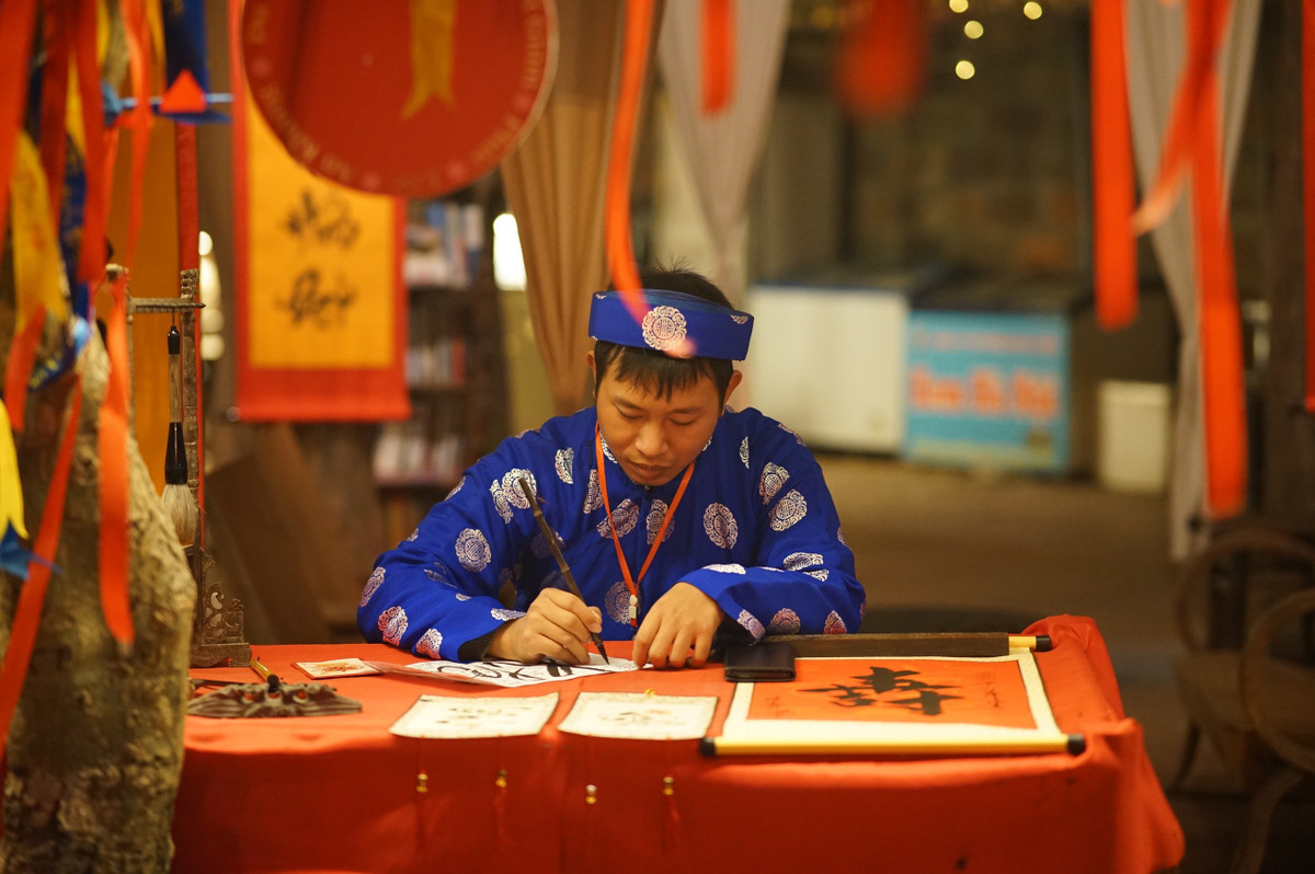 Ông đồ trẻ miệt mài họa thư pháp tại Hồ Văn.