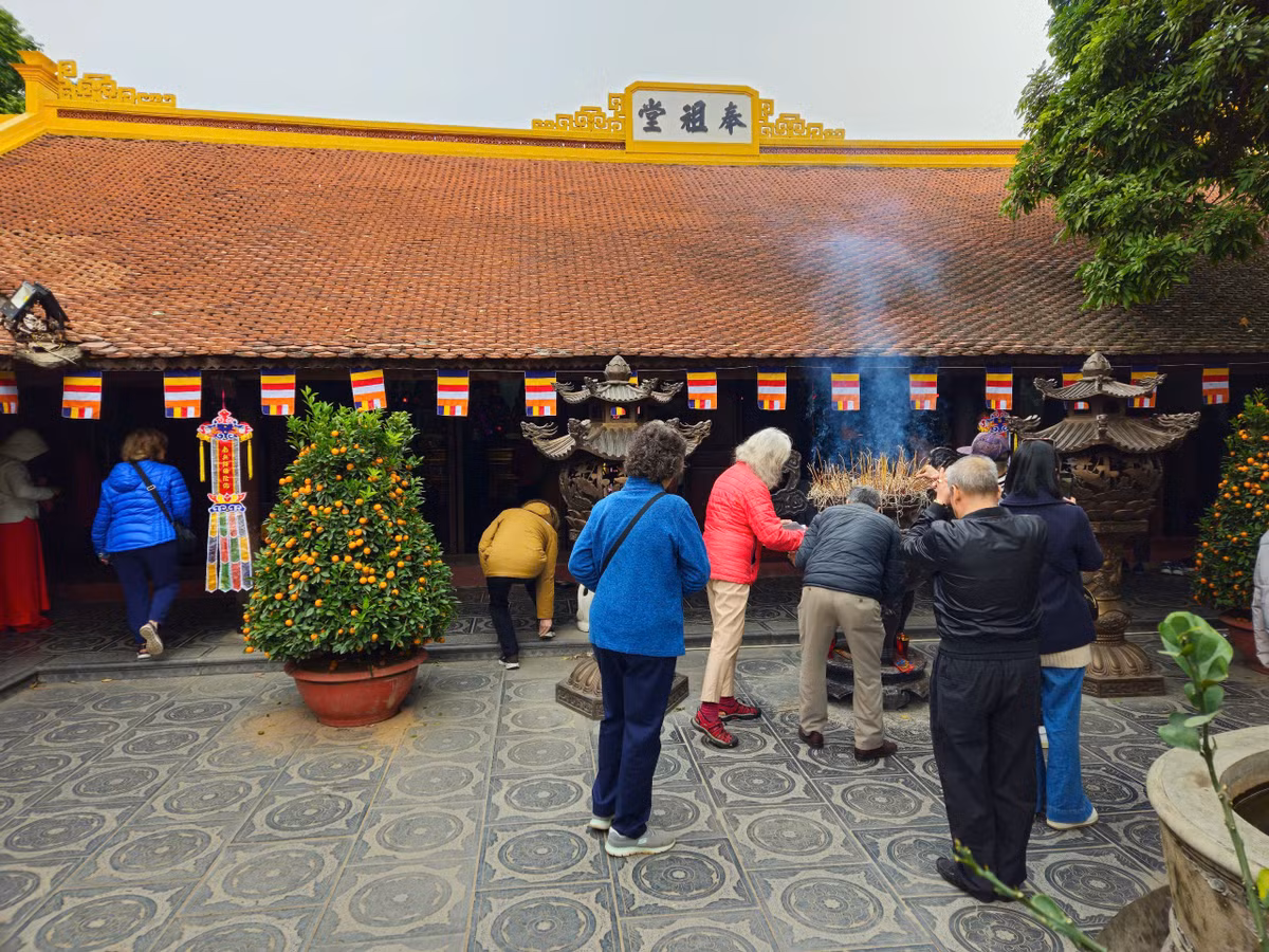 Du khách nước ngoài cũng dâng hương khi tiến vào thăm quan chùa Trấn Quốc trong sáng mùng 1 Tết.