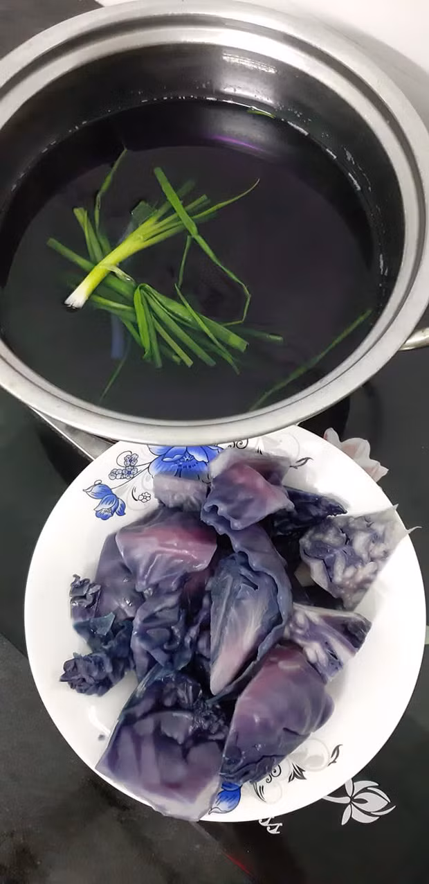 Trong ảnh, có thể thấy phần nước luộc bắp cải chuyển sang màu "tím lịm tìm sim", còn những miếng bắp cải thì loang lổ chỗ trắng, chỗ tím, chỗ xanh trông cứ như… bị đột biến!