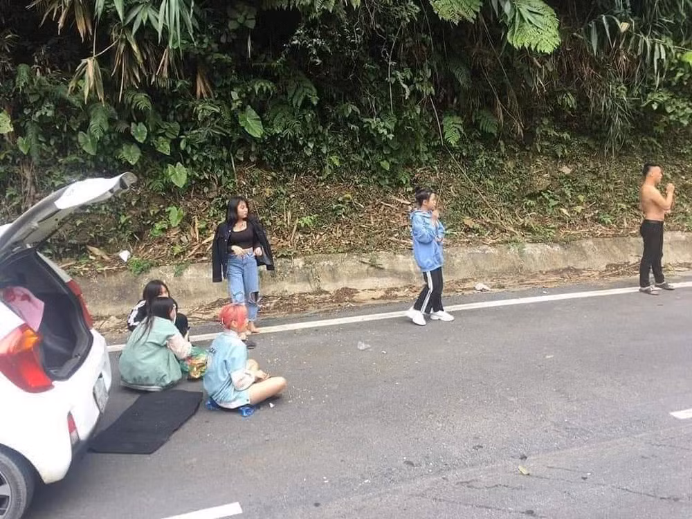 Có thể thấy chiếc xe ô tô gặp sự cố buộc phải dừng giữa đường, nhưng những người trên xe lại thản nhiên trải khăn ra đường ngồi ăn, nghỉ ngơi chiếm hết nửa lòng đường.