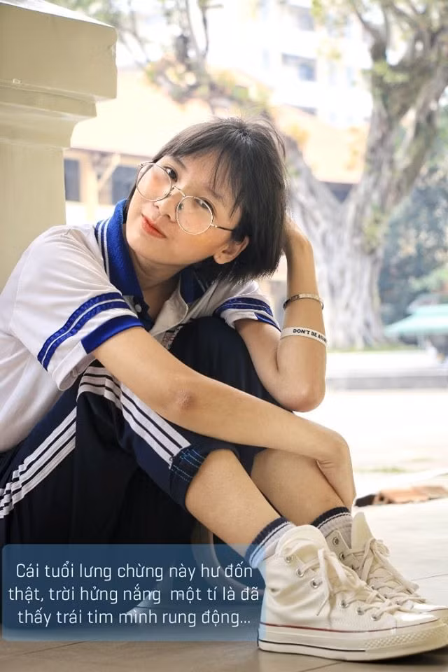 Cô nàng mặc chiếc áo dài màu hồng như bao giáo viên khác nhưng trên chân lại không phải giày cao gót, giày búp bê mà là đôi thể thao cá tính.