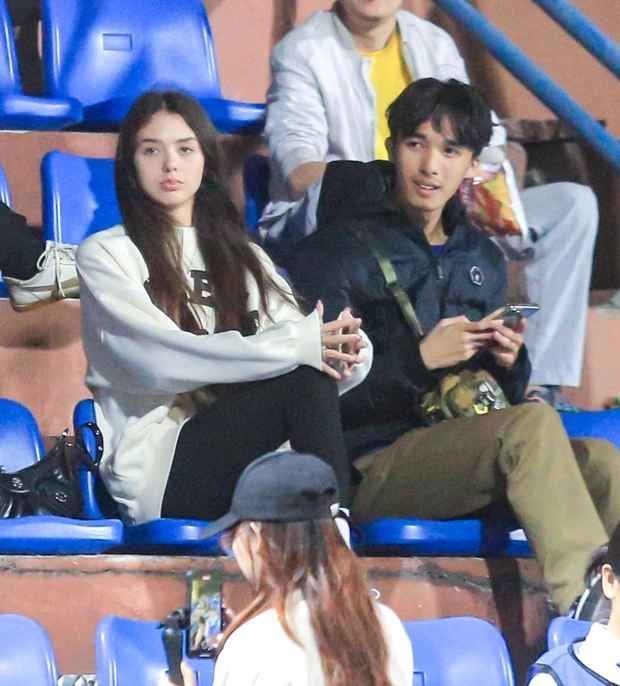 Cô nàng cùng người quen ngồi trên khán đài