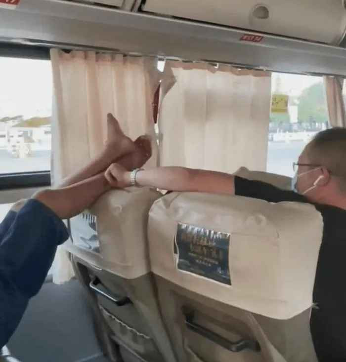 Có thể thấy rõ "đôi chân hư hỏng" của người đàn ông lộ ra phía trên ghế, đặt ngay trên đầu người khách nữ, chỉ cách vài centimet.