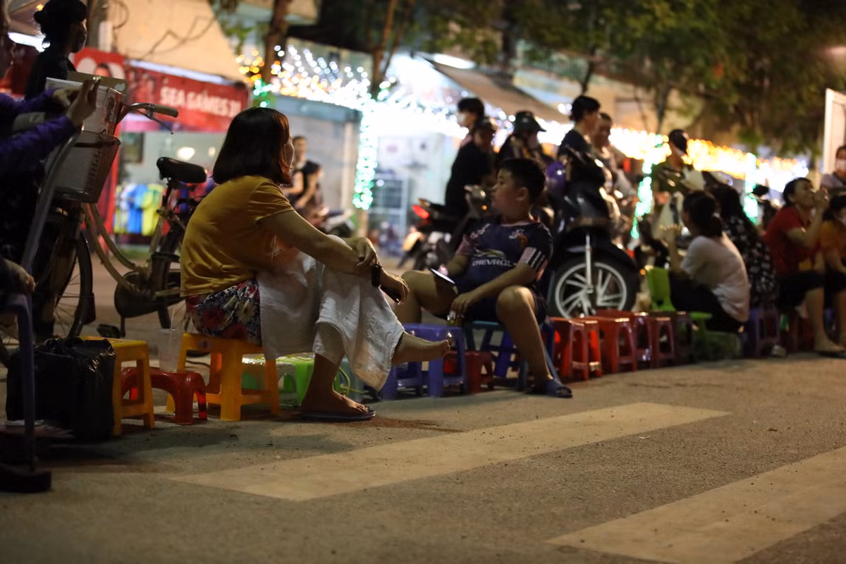 Không chỉ có người lớn mà cả trẻ nhỏ cũng tham gia công việc ngồi xếp hàng lấy vé trong đêm.