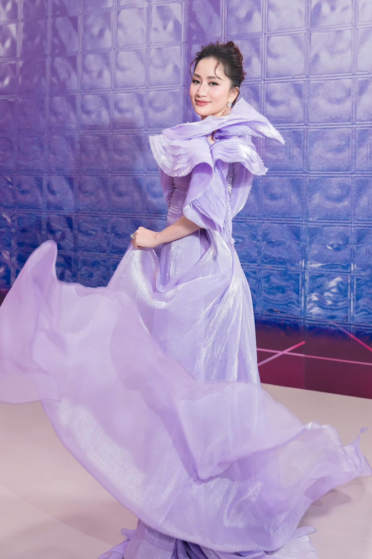 Trong sự kiện, Khánh Thi diện chiếc váy dạ hội màu trắng ánh kim lộng lẫy, thiết kế ôm sát khéo léo tôn lên vóc dáng mảnh mai và đường cong quyến rũ.