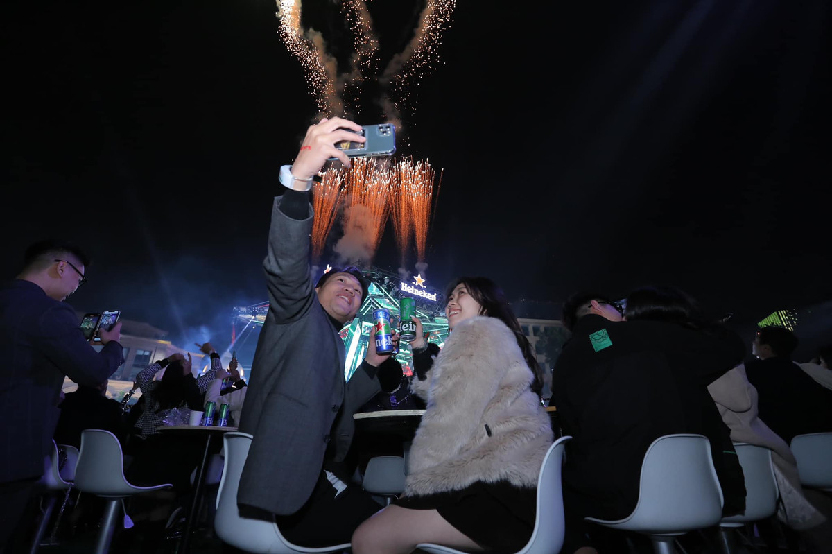 Không hôn nhau thì các cặp đôi lấy máy điện thoại tranh thủ selfie dưới màn pháo hoa chào đón năm mới.