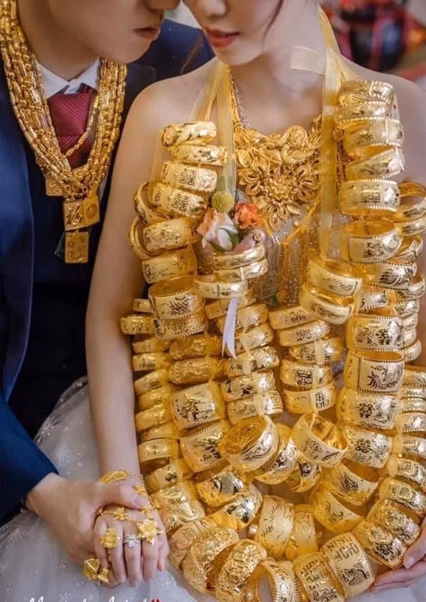 Ngoài cô dâu thì chú rể cũng được tặng dây chuyền, vòng tay và rất nhiều nhẫn vàng khiến mọi người ghen tị.