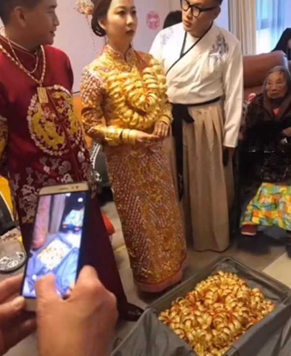 Qua đoạn video ghi lại cảnh đám cưới, có thể thấy cô dâu và chú rể đang tiến hành nghi lễ nhận quà từ người thân trong gia đình.