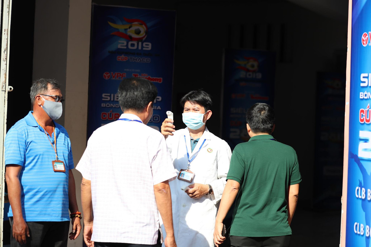 Các nhân viên y tế đứng ngay những cổng vào SVĐ tổ chức Chung kết Siêu Cúp QG 2019 để kiểm tra thân nhiệt của từng CĐV vào sân.