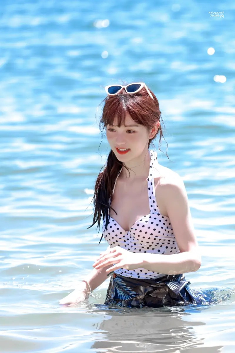 Trong hình, nữ diễn viên sinh năm 1997 diện thiết kế đồ bơi liền mảnh cổ yếm, hoạt tiết chấm bi, cô quấn thêm một lớp khăn dày bên dưới, tạo thành váy nhằm tiết chế sự gợi cảm.