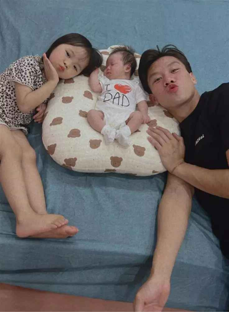 Theo đó, hậu vệ đội tuyển Việt Nam diện quần áo giản dị, đầu tóc rối bời, phụ vợ chăm ru con gái thứ 2 ngủ.