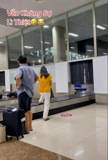 Theo hình ảnh được ghi lại trong clip, cô gái này mặc quần trắng, áo vàng đang đứng đợi hành lý ra từ băng chuyền trong sân bay cùng với một người đàn ông khác.